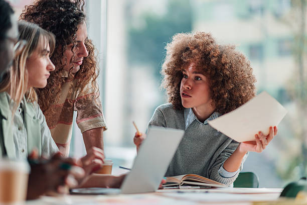 istock Diverse young adults collaborating on business project at office meeting 2251918369