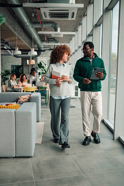 istock Diverse business colleagues walking and discussing in modern office 2251918379