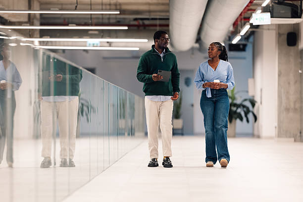 istock Business colleagues walking and talking in modern office 2251918566