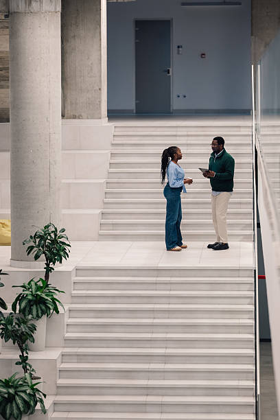 istock Colleagues having informal meeting on modern office stairs 2251918570
