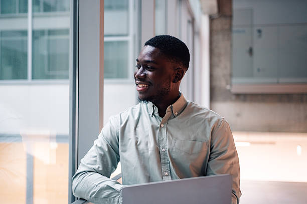 istock Smiling young man working by window in modern office 2251918650