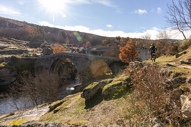 istock A man is riding a bike on a path next to a bridge 2251919147