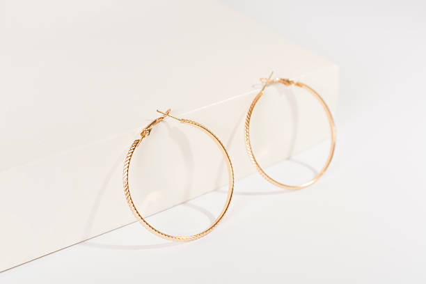 istock Golden earrings with decor on color background 2251919287
