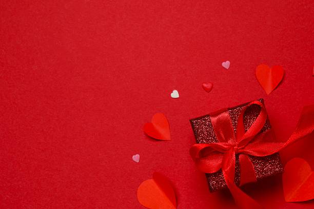 istock Festive gift box with red hearts on red background. Valentines day, Birthday or Wedding romantic concept. Festive composition. Mock up 2251919616