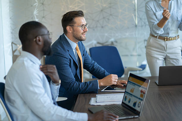 istock Business team analyzing data on tablet and laptop during meeting 2251920552