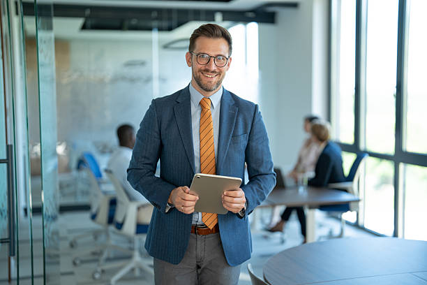 istock Smiling businessman holding digital tablet in modern office 2251920598