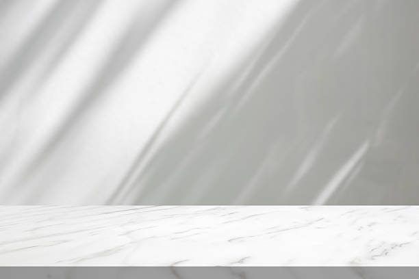 istock Marble table with tree shadow drop on white wall background for mockup product display 2251920733
