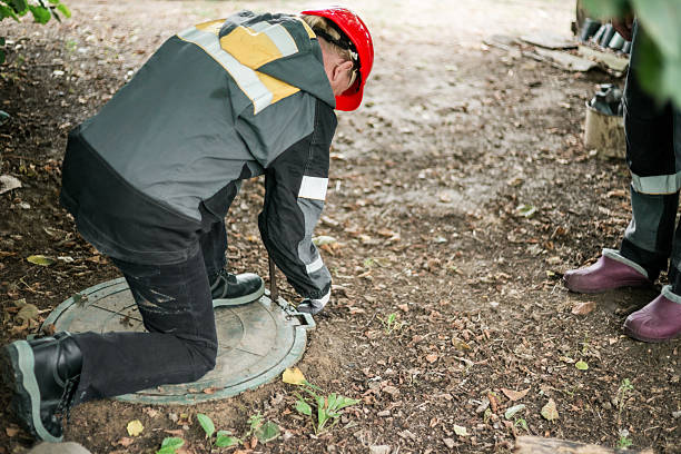 istock A worker leaned over a septic tank to open it for maintenance 2251920948