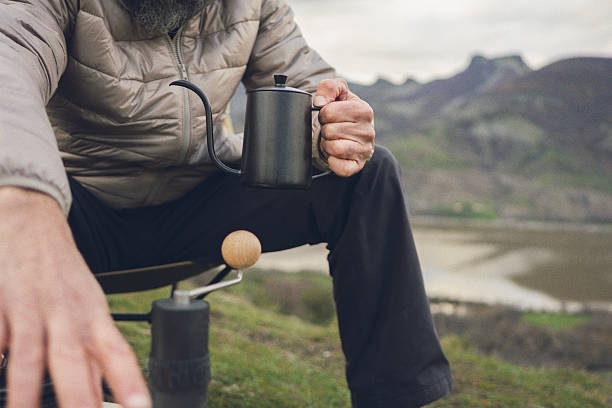 istock Man Preparing Fresh Coffee While Camping Outdoors 2251920989