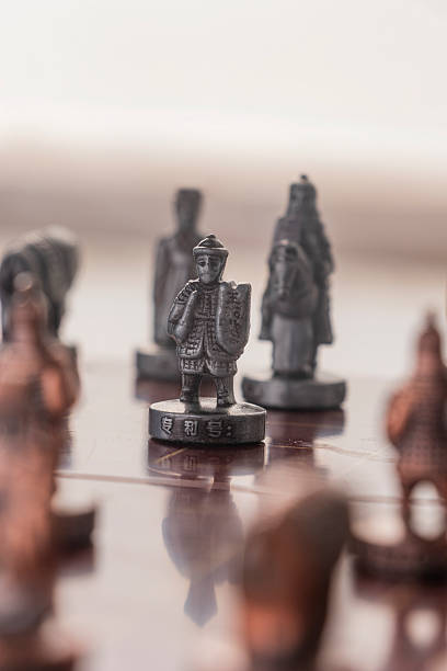 istock Ancient Strategy: Copper General and Chariot on Dark Wood Chessboard 2251922418