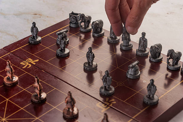 istock Oriental Game Theory: The Red and Copper Armies Face Off on a red chess board Grid. 2251922436