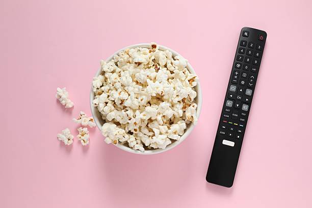 istock Popcorn and TV remote controller on color background 2251923060