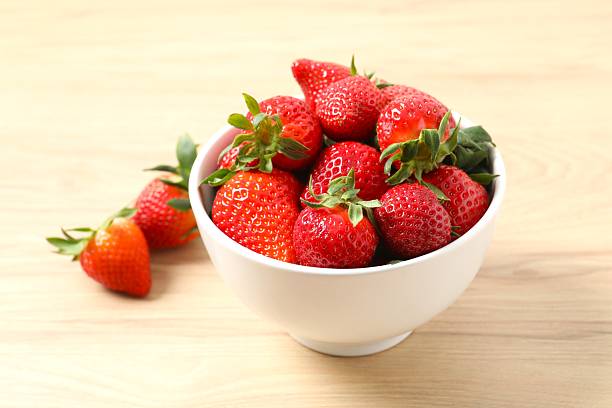 istock Delicious fresh red strawberries in a bowl on a light background 2251923362