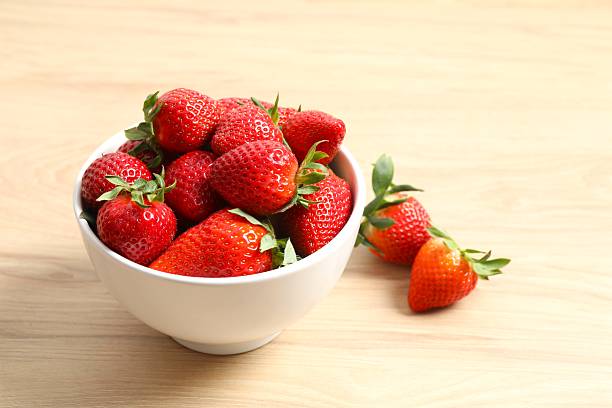 istock Delicious fresh red strawberries in a bowl on a light background 2251923369