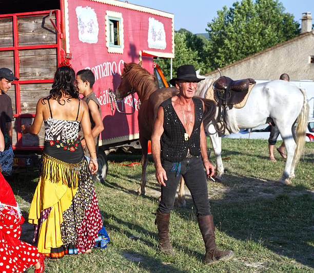 This thrilling Romani show took place in Ongles, Alpes de Haute Provence, France on the 3 July 2010.  Their Romani culture is of nomadic in nature. These erformers are gathering outside the touring vehicle. The public were warmly welcomed.