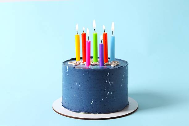 istock Birthday cake with candles on blue background 2251923702