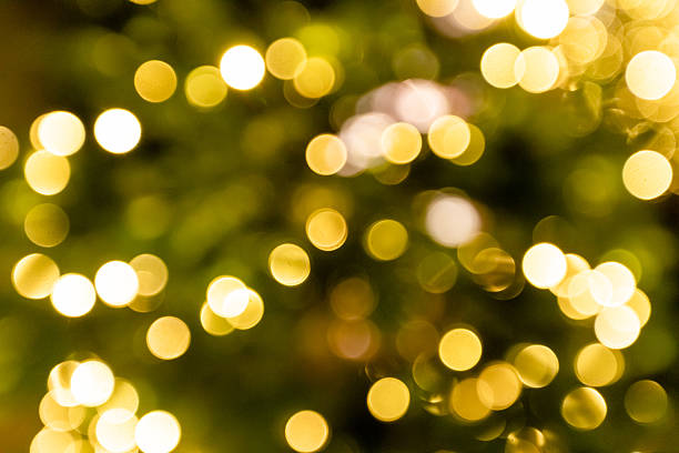 Defocused Christmas lights creating abstract golden bokeh circles, suitable for festive seasonal backgrounds and visual design use.