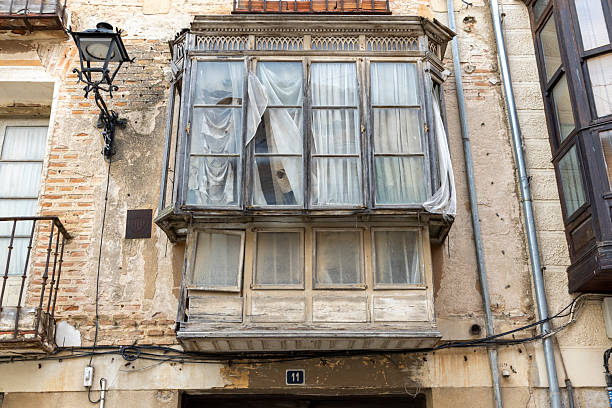 A window with a sign on it that says 11. The window is open and has a curtain hanging from it