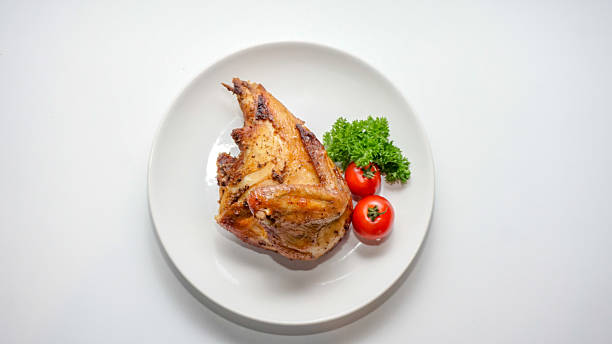 istock Roasted Chicken Portion with Fresh Herbs and Tomatoes on White Plate – Overhead View 2251925949