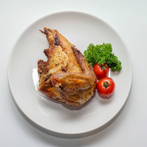 istock Roasted Chicken Portion with Fresh Herbs and Tomatoes on White Plate – Overhead View 2251926056