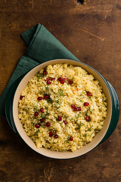 Tabbouleh salad with couscous in a bowl on the black table. Levantine vegetarian salad