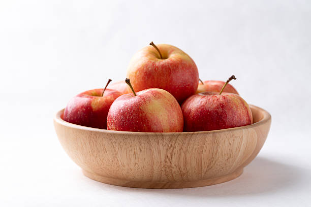 istock Red apple fruit (Gala apple) in wooden bowl on white background 2251930876