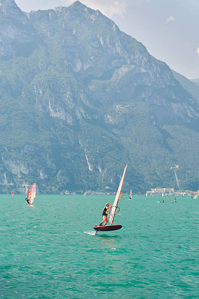 Torbole sul Garda, Italy – August 14, 2025: Windsurfers on Lake Garda photographed from Torbole sul Garda. Riva del Garda in the background.