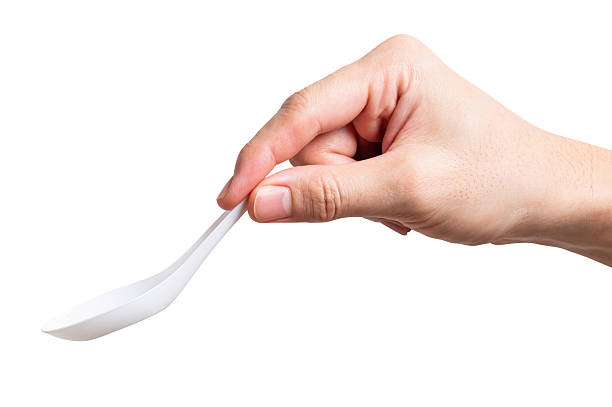 istock Male hand holding a white plastic spoon isolated on white background. 2251935485
