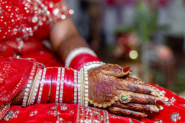 istock Indian bride's hands adorned with henna, bangles, and a ring during a wedding ceremony 2251937334