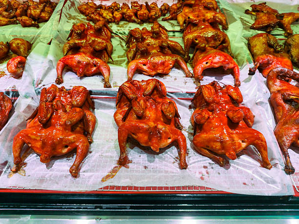 A display of succulent roasted chickens, perfectly marinated in rich, vibrant red sauces, enticing viewers with their glossy appearance at a traditional market.