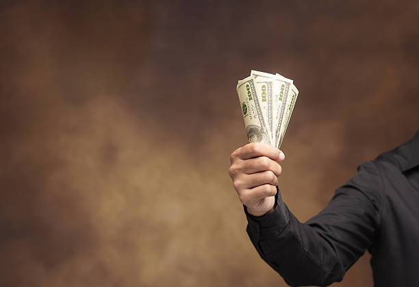 istock Hand presenting cash banknotes as financial concept. 2251939800