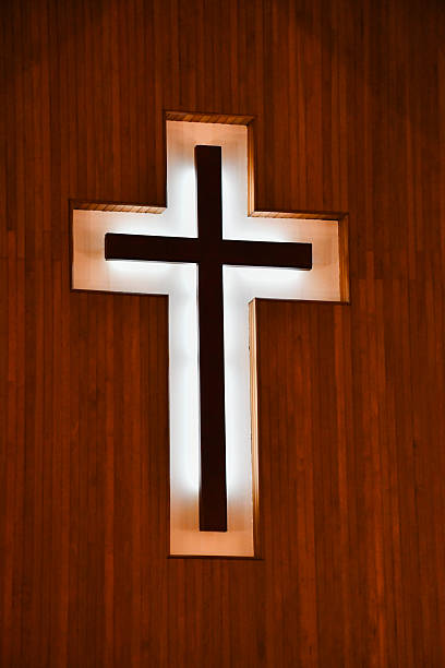 istock Illuminated Wooden Cross in Church Interior 2251942302