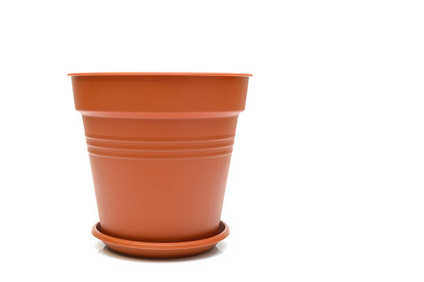 close-up of a new brown plastic flower pot with a saucer, placed on the left side of a white background, leaving sufficient empty space on the right for text or graphics