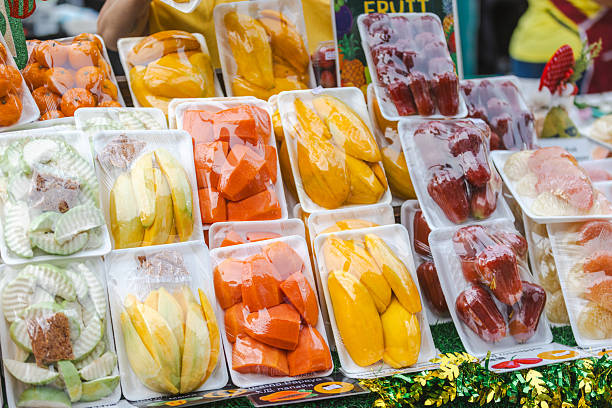 Peeled tropical fruits on street market display.