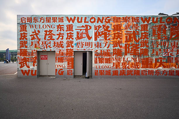 Shanghai, China - October 14, 2023: A lively Shanghai street scene featuring a bold blue mural on a building, with pedestrians, cyclists, and visitors enjoying a sunny day in a modern urban plaza.