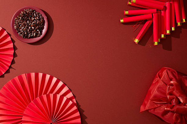 istock Top view of red fans, firecrackers, and tea elements on red surface. Chinese New Year flat lay background for Lunar New Year marketing and festive design. Space for text 2251955723