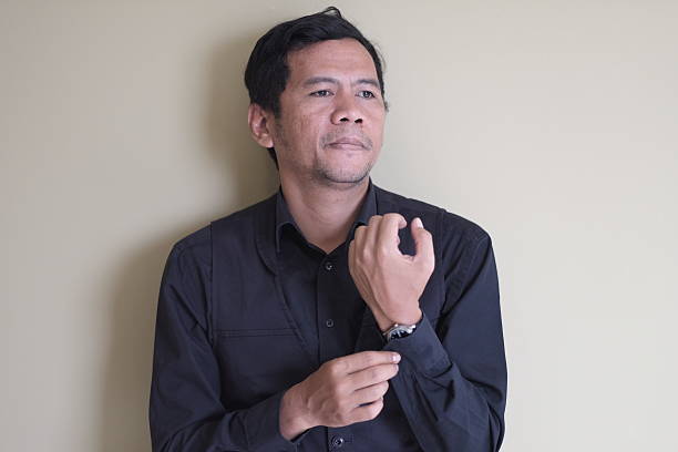 Professional Man Adjusting His Shirt Cuff with a Thoughtful Expression