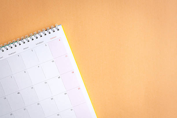 2025 October month calendar and thumbtacks on orange background. Calendar and reminder concept.