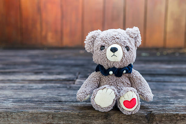 istock Teddy bear and red heart mark with space on wood background 2251958365