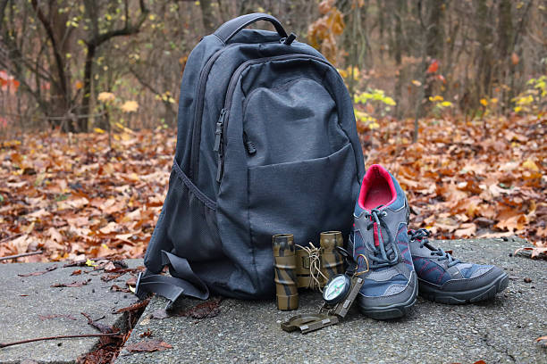 istock Tourist backpack, hiking boots, picnic utensils and hat on a path on the mountainside in the forest. 2251959939