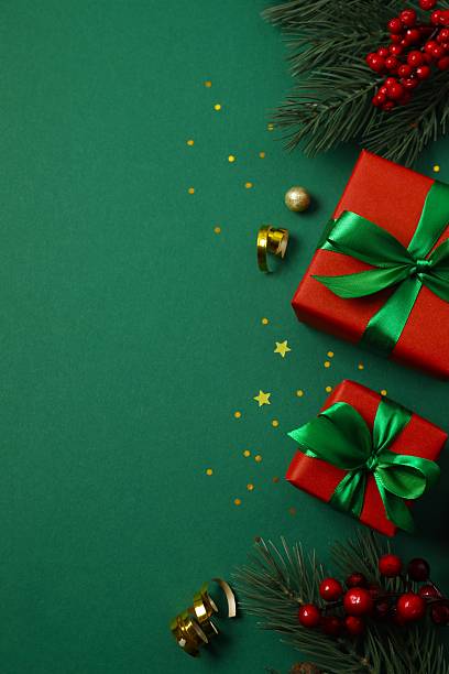 istock Beautiful gift boxes tied with bows and Christmas decorations on color background 2251968323