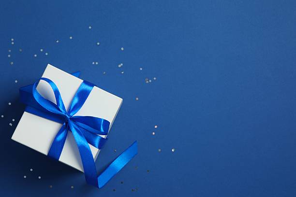 istock Creative gift box with confetti on color background, top view 2251968573