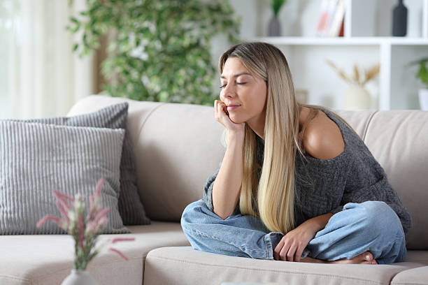 istock Relaxed blonde woman sitting on a couch 2251968958
