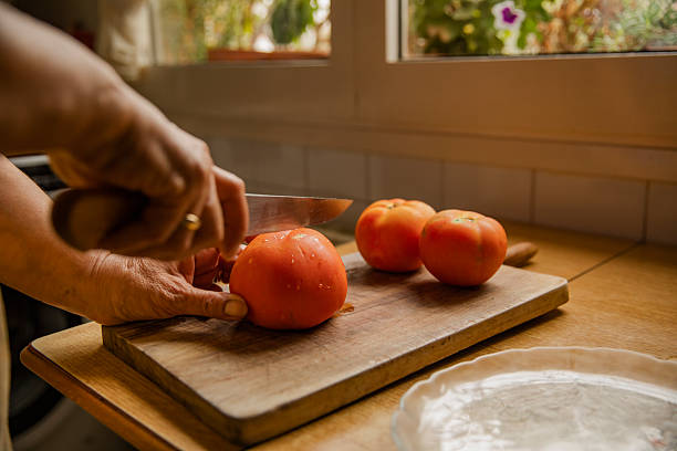 istock Cutting Fresh Tomatoes on Wooden Board 2251974988