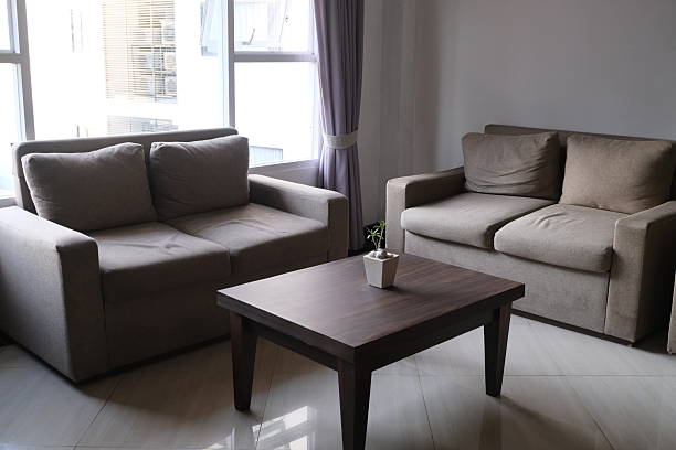 Simple-style living room featuring an armchair, grey sofa, coffee table, and living room cabinet, set against ceramic-tiled flooring and a white wall background.