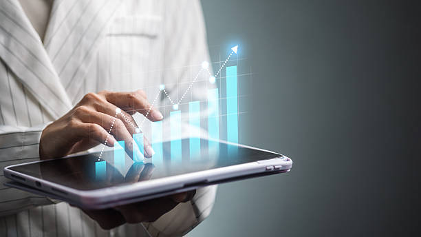 istock Business analyst using tablet with rising bar chart and growth line 2251980376