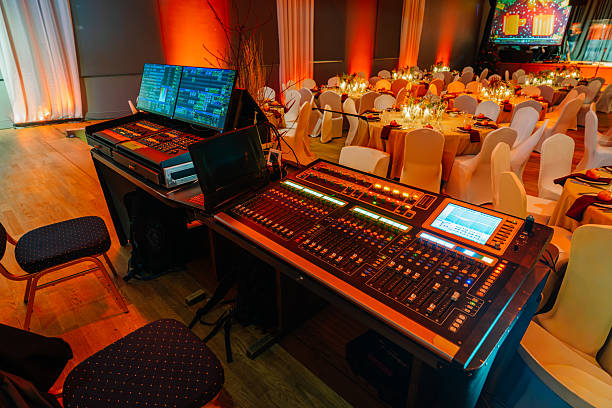 istock Audio mixing console in a beautifully decorated event space with elegant tables and chairs, showcasing vibrant lighting and a festive atmosphere for celebrations and gatherings 2251981130