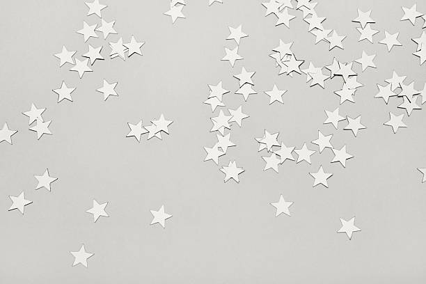 istock Cloud dancer colored star confetti sprinkling on solid gray background. Color of the Year Concept 2251985693