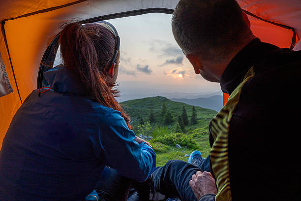 istock Couple Watching Sunset from Tent on a Mountain 2251985983