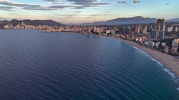 istock Large Ocean Meeting Cityscape, Broad Ocean Horizon With Distant Structures Beneath Sunny Sky 2251987470